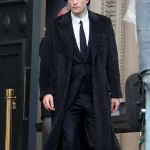 Robert Pattinson wearing The Batman black wool coat in a front zoomed-out view, showcasing the full silhouette and design.