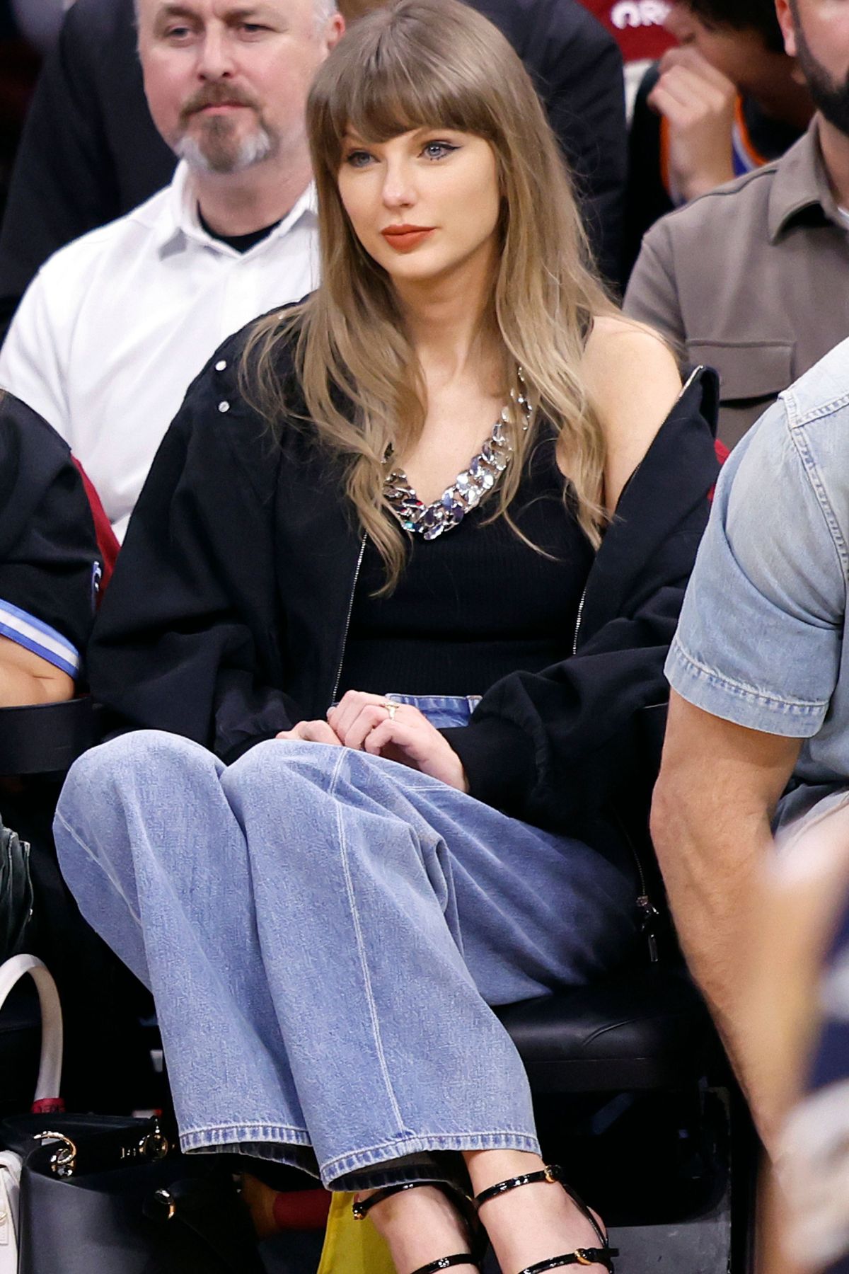 taylor-swift-new-york-knicks-game-2026-black-denim-jacket-01 Taylor Swift Knicks Game 2026 Stella Mccartney Black Patchwork Denim Bomber Jacket